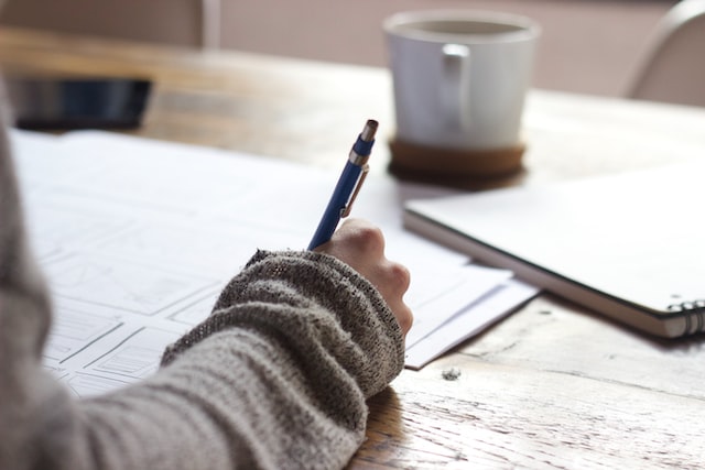 Close up of woman writing notes for cash flow forecasting plan